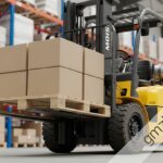 Forklift lifting another forklift during heavy equipment recovery operation at construction site